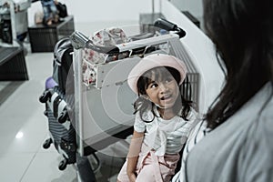 Asian pregnant woman and her daughter sitting in the waiting room airport