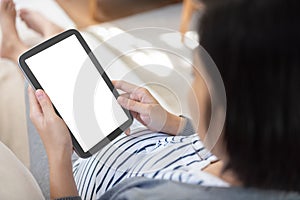 Asian pregnant woman holding digital tablet