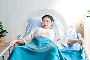 Asian pregnant woman Lying in a patient`s bed in the hospital she had a stomach ache