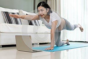 Asian Pregnant woman practicing yoga at home