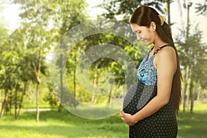 Asian pregnant woman touching her belly with hands