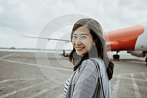 Asian pregnant women pulling suitcases while walking on the runway