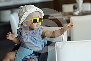 Asian pretty baby girl win comforatble mood with her yellow sunglasses and awesome action