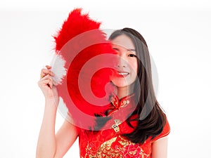 Asian pretty girl hide her face behind red feather fan and wear cheongsam to promote Chinese fashion style isolated on white