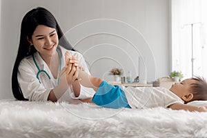 Asian pretty woman is using her hands to massage child feet