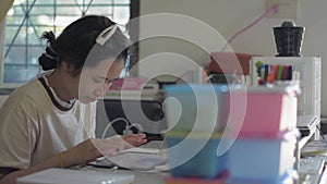 Asian pretty young woman in casual dress typing digital tablet on working desk.