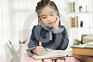 Asian primary school student studying homework in home