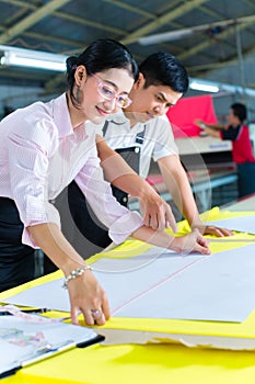 Asian production manager and designer in factory