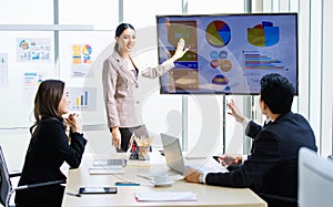 Asian professional businesswoman in formal suit standing showing presenting explaining report investment graph chart
