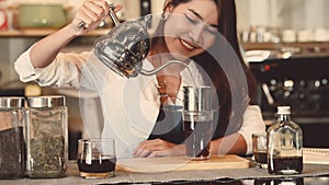 Asian professional female barista making cup of coffee at counter bar in cafeteria restaurant as shop owner. Waitress girl making