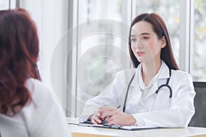 Asian professional  female doctor suggests healthcare solution to her patient elderly in examination room at hospital