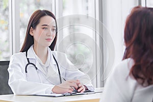 Asian professional  female doctor suggests healthcare solution to her patient elderly in examination room at hospital