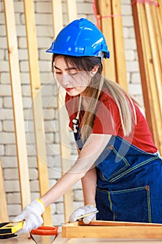 Asian professional female engineer architect foreman labor worker wears safety goggles, helmet, apron and gloves standing smiling