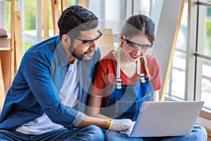 Asian professional female and Indian bearded male engineer architect foreman labor worker wear safety goggles and gloves sitting