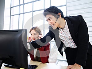 Asian professional manager pointing finger on computer for explain analysis strategy with call center woman before meeting with