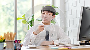 Asian professional successful male businessman employee in formal shirt with necktie sitting hold coffee cup waving hand greeting