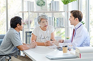 Asian professional successful male doctor in white lab coat with stethoscope hold medicine pill bottle showing explaining dosage