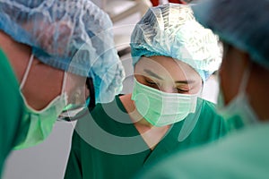 Asian professional surgeon team Operate on a patient lying on a bed in an operating room in a hospital.