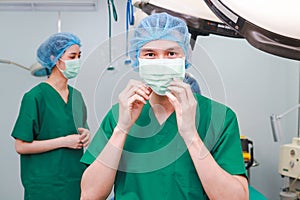 Asian professional surgeon team Operate on a patient lying on a bed in an operating room in a hospital.