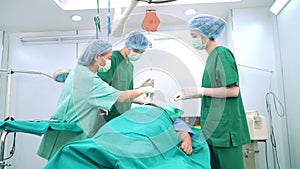Asian Professional surgeons team performing surgery in the operating room, surgeon, Assistants, and Nurses Performing Surgery on a