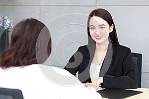 Asian professional woman is working and pointing on the paper or document to discuss with her boss at office
