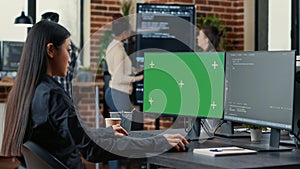 Asian programer writing code in front of computer with green screen chroma key mockup