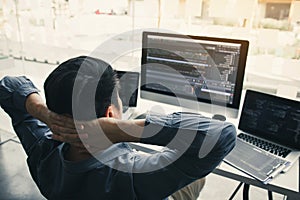Asian programmers man are relaxing and looking at the code on the computer screen in the office