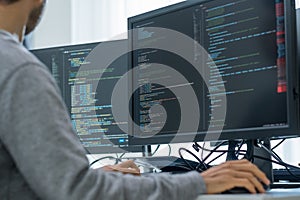 Asian prompt engineer developer coding app with software data sitting in front of computer monitor at office