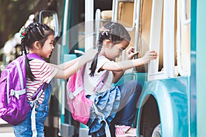 Asian pupil kids with backpack holding hand and going to school