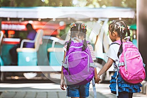 Asian pupil kids with backpack holding hand and going to school