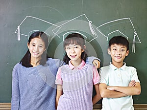 Asian pupils standing underneath chalk-drawn doctoral hat