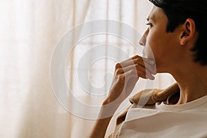 Asian puzzlement boy looking aside while resting at home