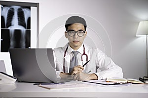 Asian qualified physician in health care facility paying attention and listening to patient for diagnosis and treatment plan