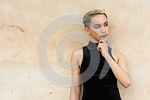 Asian queer LGBT community supporter man with mustache wearing lipstick and jumpsuit thinking photo