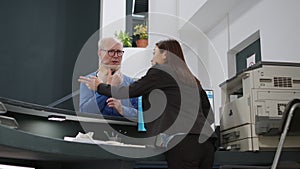 Asian receptionist helping senior man with cervical neck collar