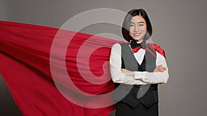 Asian receptionist posing with red superhero cape on camera