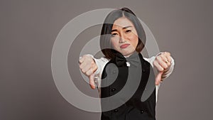 Asian restaurant hostess showing thumbs down and dislike sign