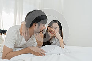 Asian Romantic couple in bed enjoying sensual foreplay Happy sensual young couple lying in bed together. Beautiful