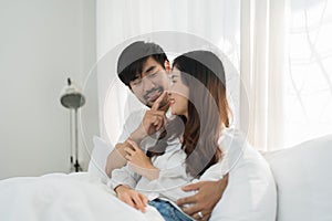 Asian Romantic couple in bed enjoying sensual foreplay Happy sensual young couple lying in bed together. Beautiful