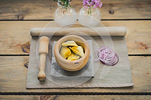 Asian samosas with red onion on wood recipient photo