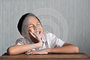 Asian school boy in pain holding his cheek because of toothache