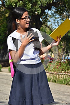 Asian School Girl Reading Wearing School Uniform With School Books