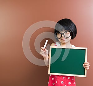 Asian school kid with chalk and chalkboard