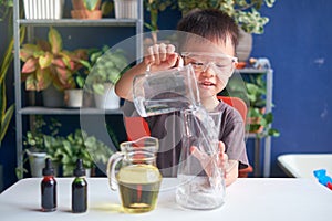 Asian school kid studying science, making DIY Lava Lamp Science Experiment, Kid-friendly fun and easy science experiments at home photo