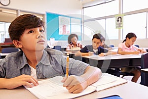 Asian schoolboy in elementary school class looking at board