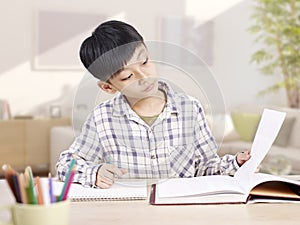 Asian schoolboy studying at home photo