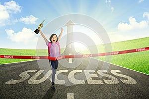 Asian schoolgirl crossing the finish line