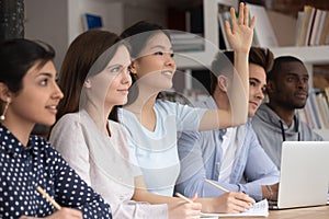 Asian schoolgirl raise hand want to answer or ask question