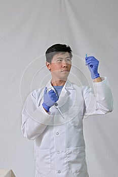 Asian scientist holding pipet and test tube
