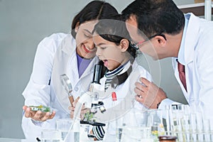Asian scientist kid student and Indian teacher have fun with plant at biology class in school laboratory, do an experiment, using